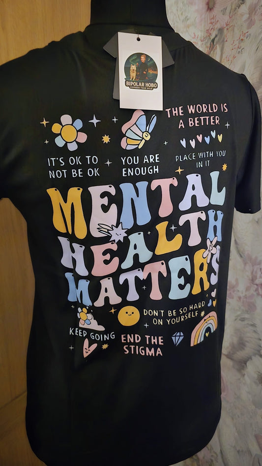 Black t-shirt with colorful text and graphics promoting mental health awareness, on a plain background.