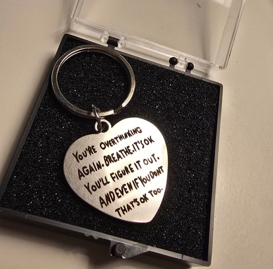 Heart-shaped keychain with motivational quote in a black box