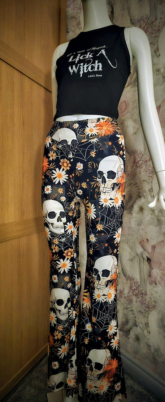 Mannequin wearing a black sleeveless top with text and floral skull pants.