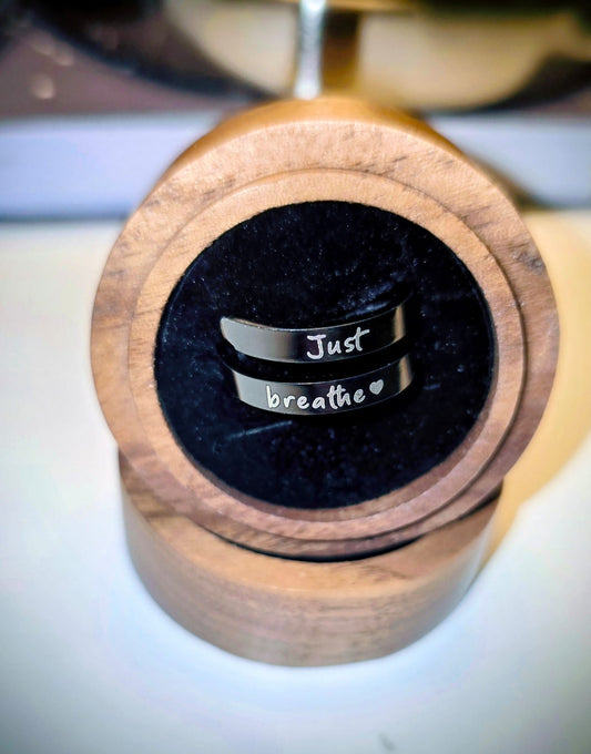 Silver ring with 'Just breathe' engraving in a wooden box