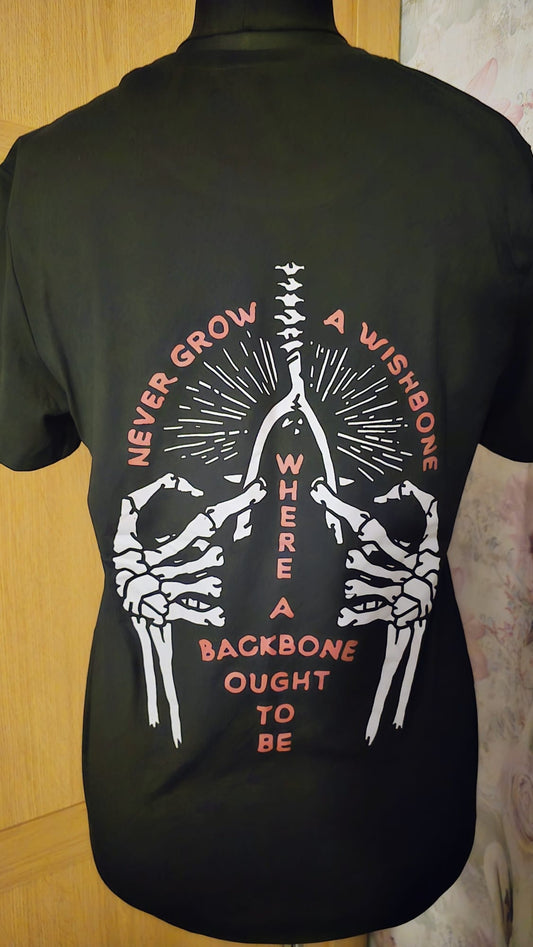 Black t-shirt with skeleton design and text on the back, against a wooden surface.