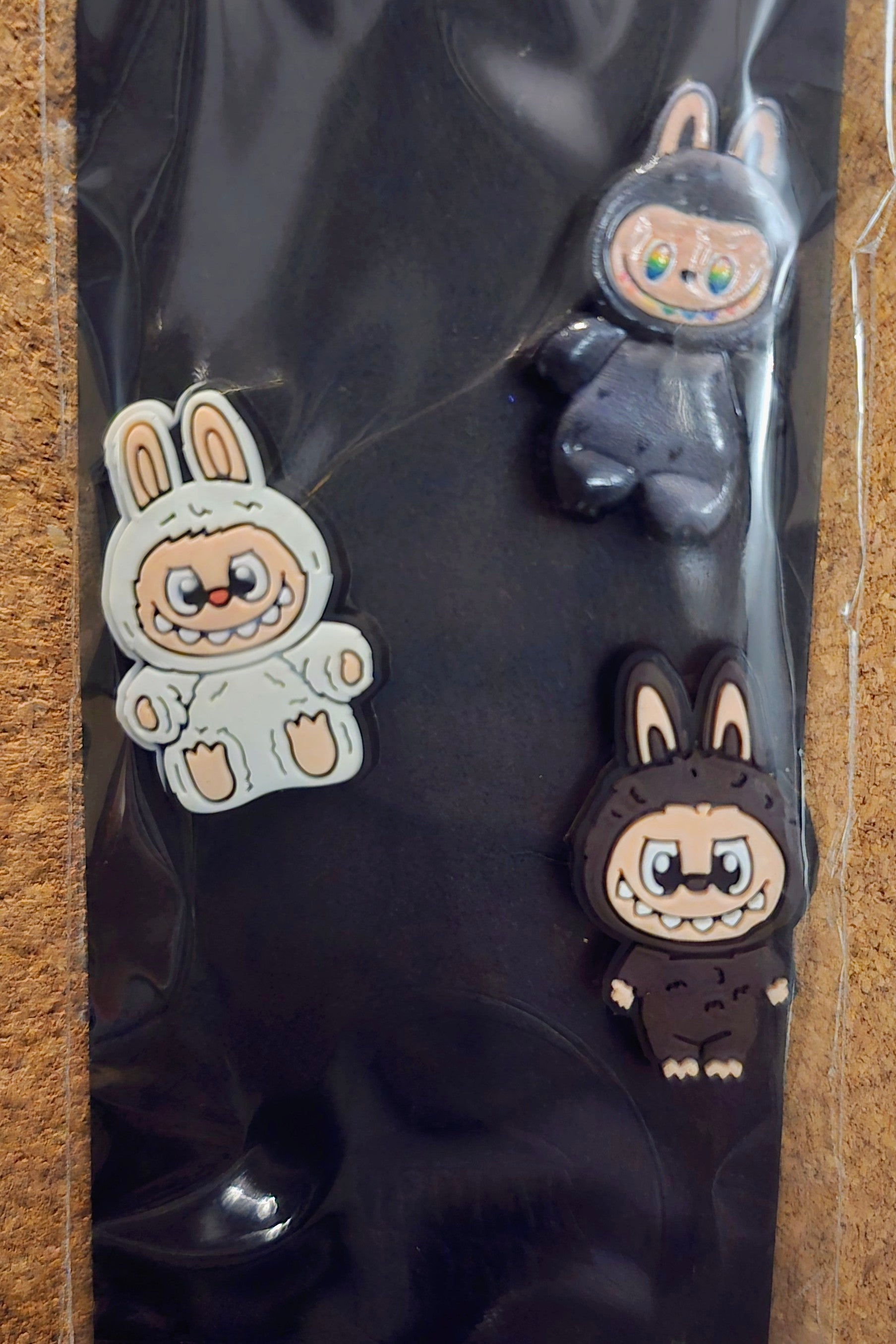 Three cartoon-style animal figurines on a reflective black surface
