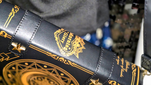 Black leather bag with gold embroidery and designs, featuring a brand logo.